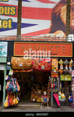 a shop front and small business selling fabrics, clothes and materials in the shopping area of Camden market London UK Foto Stock