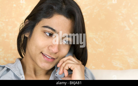 Una giovane donna che parla al telefono Foto Stock