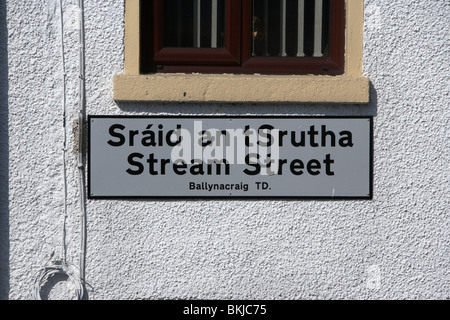 Rettificato ortografia irlandese su una strada bilingue sign in gaelico e flusso di inglese street newry contea di Down Irlanda del Nord Regno Unito Foto Stock