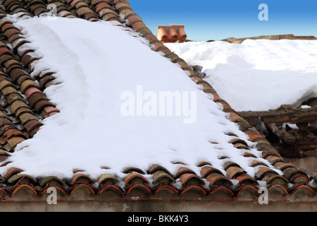 Età di argilla tegole del tetto nevicato sotto la neve dettagli dell'architettura Foto Stock