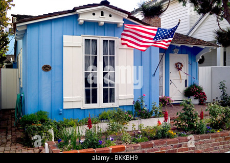 Bandiere, fiori e data storica placche spesso adornano le affascinanti e cottage colorati sull Isola Balboa in Newport Beach, nel sud della California, Stati Uniti d'America. Foto Stock
