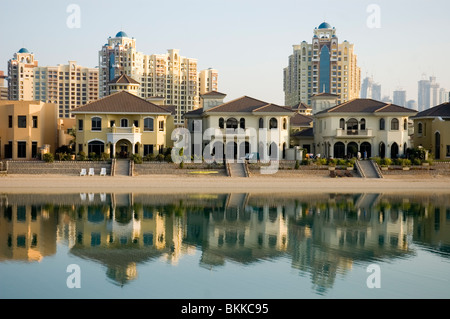 Una vista di case su un frond del Palm Jumeirah a Dubai con blocchi di appartamenti e la città di Dubai in background Foto Stock