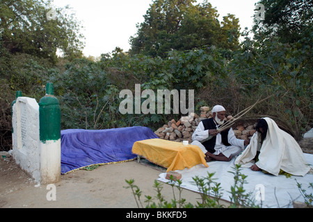 Un Sufi uomo santo o Pir, esorcizza lo spirito da una donna ad una dargah o santuario nella parte Sud di Delhi, India Foto Stock