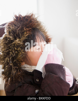 Ragazza cinese nel ricoprire il naso di soffiatura Foto Stock