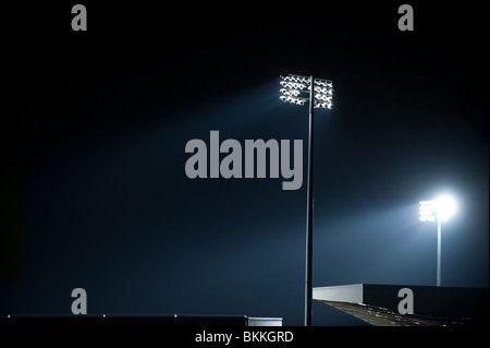 Due faretti brillano al Fulham il Craven Cottage durante una partita di notte. Foto Stock