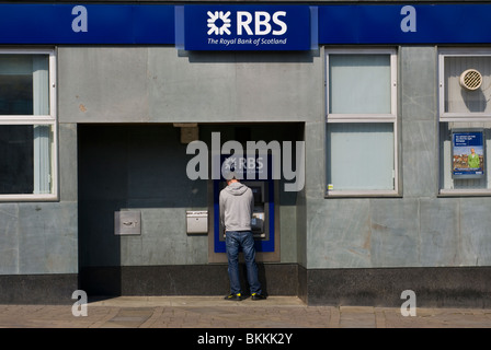 Uomo che utilizza un Bancomat presso una filiale della Royal Bank of Scotland Foto Stock