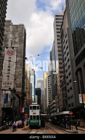 Vista frontale di un double-decker tram al mercato occidentale Stop al di sotto della torre di blocchi di Des Voeux Road Central, Hong Kong, Cina Foto Stock