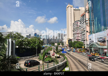Il traffico sul Victoria Park Road guardando verso l'Hotel Excelsior e lontane torri di Causeway Bay, Hong Kong, Cina Foto Stock