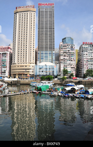 Case galleggianti ormeggiate nei riflessi del Hotel Excelsior e il World Trade Center, Causeway Bay Typhoon Shelter, Hong Kong Foto Stock