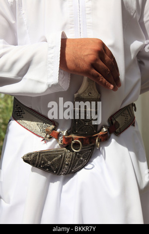 Mano d'uomo azienda tradizionale khanjar cerimoniali o curvo pugnale indossando dishdasha, Sultanato di Oman.Foto di Willy Matheisl Foto Stock