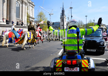 Città di Londra il poliziotto in moto tenendo alto il traffico durante il St Georges parata del giorno Foto Stock