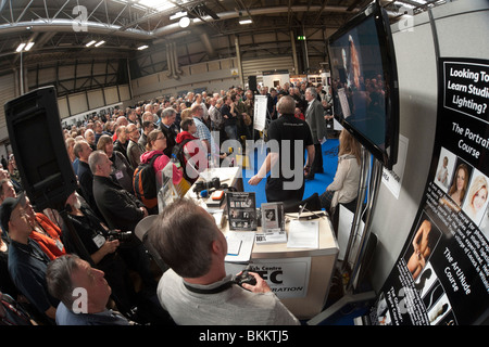 Focus sulla formazione di immagini 2010 trade show UK - DJ e fotografo Dave Lee Travis parla di fronte a un pubblico numeroso folla. Foto Stock