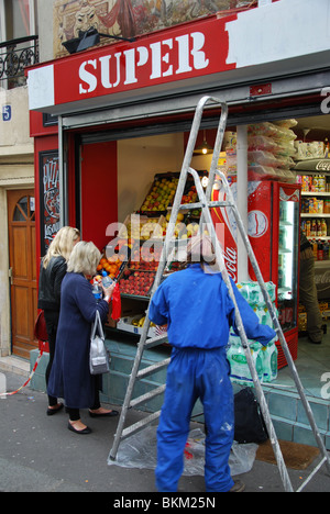 Donna segno scrittura segno di supermercati e Montmartre a Parigi Foto Stock