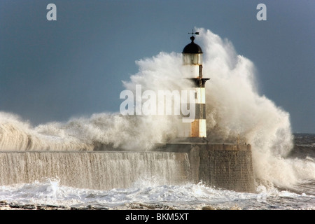 Seaham, Teesside, Inghilterra; onde si infrangono in un faro Foto Stock