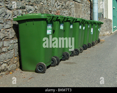 Una linea di verde wheelie bin contenenti materiale riciclabile in attesa collezione - Civitanova Marche, regione settentrionale della contea di Dublino, Irlanda Foto Stock