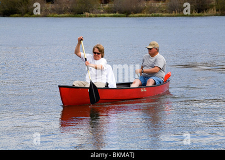 Il sovrappeso dei cittadini anziani canoa in una piccola canoa sul fiume Deschutes in curva, Oregon Foto Stock