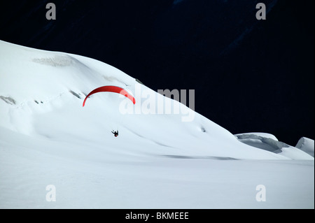 Deltaplano in arrivo a terra sulla coperta di neve montagna. Foto Stock