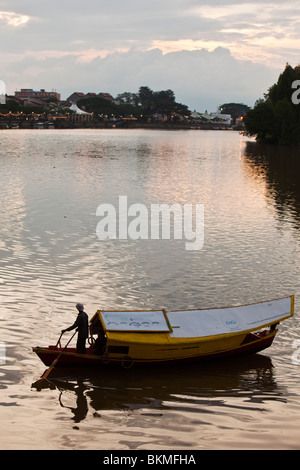 Un tambang (sampan taxi d'acqua) si stagliano sul Fiume Sarawak al crepuscolo. Kuching, Sarawak, Borneo Malese. Foto Stock
