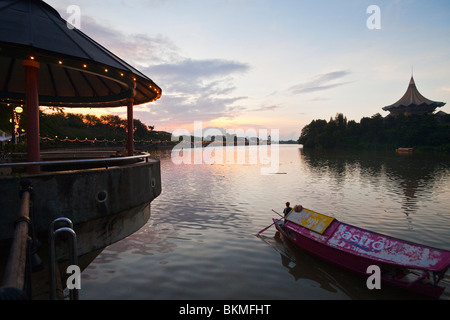 Un tambang (tradizionali taxi d'acqua) le crociere fino al Fiume Sarawak al crepuscolo. Kuching, Sarawak, Borneo Malese. Foto Stock