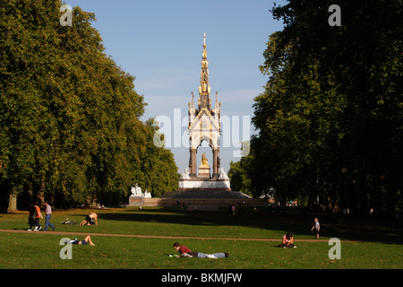 Prendere il sole e rilassarsi di fronte all'Albert Memorial nella zona londinese di Kensington Gardens Foto Stock