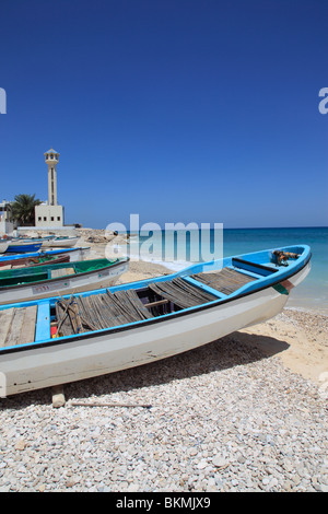 Barche da pesca, la moschea e il minareto in spiaggia nel villaggio di alette , Mare Arabico, il sultanato di Oman. Foto di Willy Matheisl Foto Stock