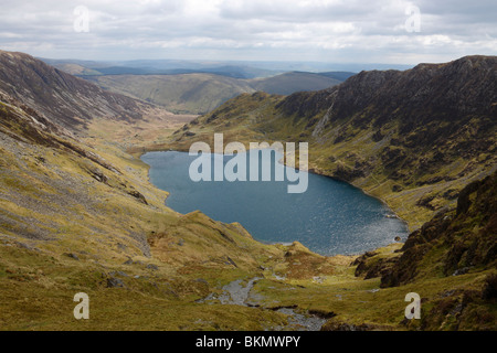 Il lago di Llyn Cau accoccolato sotto la grande scogliera di Craig Cau sulla montagna di Cadair Idris in Snowdonia, il Galles del Nord Foto Stock