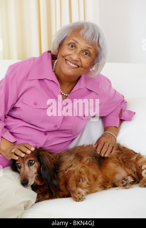 Senior americano africano donna petting cane Foto Stock