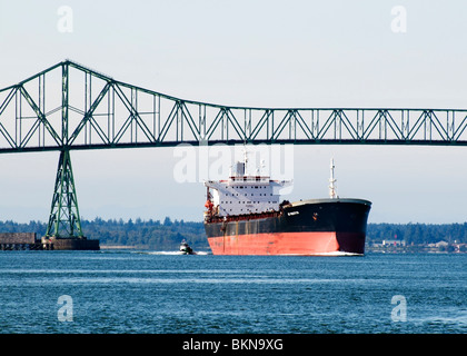Una nave portacontainer scortati da un rimorchiatore che passa sotto il ponte Astoria-Megler in Oregon. Foto Stock