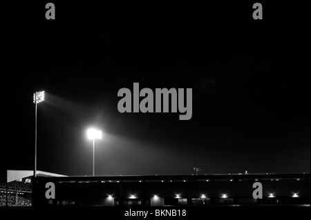 Due faretti brillano al Fulham il Craven Cottage durante una partita di notte. Foto Stock