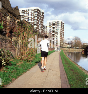 Un uomo jogging lungo l'alzaia del Regents Canal vicino Hoxton, East London, England Regno Unito KATHY DEWITT Foto Stock