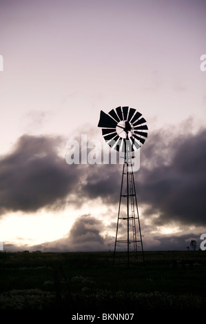 Mulino a vento stagliano contro le nubi Foto Stock