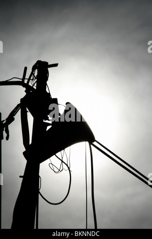 Una silhouette megafono sul polo di proprietà abbandonati Foto Stock