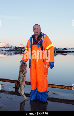 Un pescatore mantiene una sua linea di merluzzo pescato il pesce in Ballstad borgo peschereccio di Vestvågøy, una delle isole Lofoten in Norvegia Foto Stock