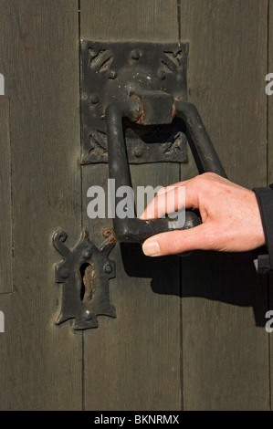 Primo piano della mano mans che tiene la vecchia maniglia della portiera Foto Stock