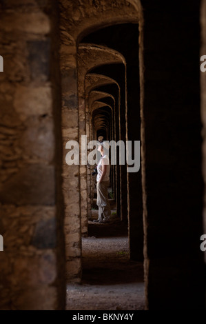 Un turista cammina dentro la archi multipli all'interno di una area abbandonata miniera d'oro, dei minerali de Pozos, San Luis de la Paz, Messico. Foto Stock