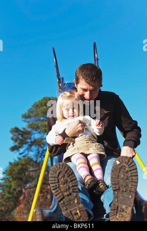 Un padre e figlia di andare giù a far scorrere insieme a un parco giochi Foto Stock