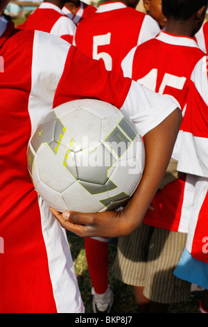 Bambino tenendo palla calcio Foto Stock