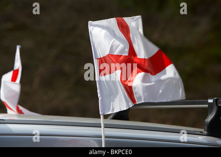 Mini cross di St George inglese bandiera nazionale a volare su un auto su st georges day England Regno Unito Foto Stock