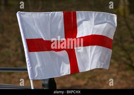 Mini cross di St George inglese bandiera nazionale a volare su un auto su st georges day England Regno Unito Foto Stock