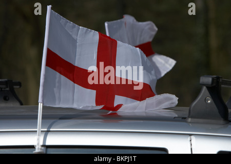 Mini cross di St George inglese bandiera nazionale a volare su un auto su st georges day England Regno Unito Foto Stock