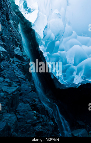 Una cascata di rivoli verso il basso la roccia di una caverna di ghiaccio all'interno dell'Mendenhall Glacier, Juneau, AK. L'estate. Foto Stock