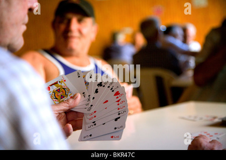 Italia Meridionale e Sicilia, Pozzallo. Pensionati uomini uccidere tempo giocando a carte in un tipico club. Foto Stock