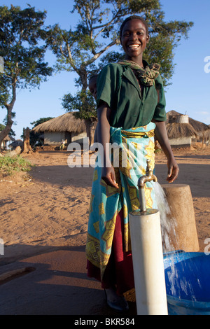 Il Malawi, Lilongwe, Ntchisi Riserva Forestale. Con una alimentazione di acqua pulita gli abitanti del villaggio si riuniscono per raccogliere l'acqua Foto Stock