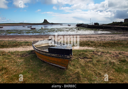 Vecchia barca da pesca e Lindisfarne Castle attraverso il Porto Santo Isola Northumberland REGNO UNITO Foto Stock