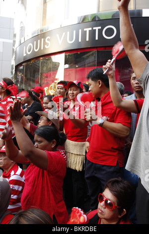 Maglietta rossa dimostranti di campagna contro il governo, stanno protestando davanti a Louis Vuitton shop nella zona centrale di Bangkok. Foto Stock