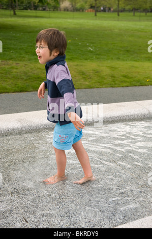 Due bambini che giocano per il Princess Diana Memorial fontana in Hyde Park, Londra. Foto Stock