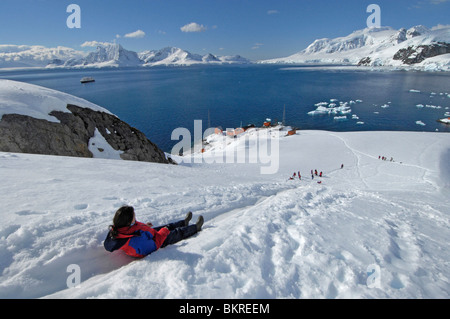 Donna in discesa di scorrimento alla base antartica Almirante Brown in Paradise Bay, Penisola Antartica, Antartide Foto Stock