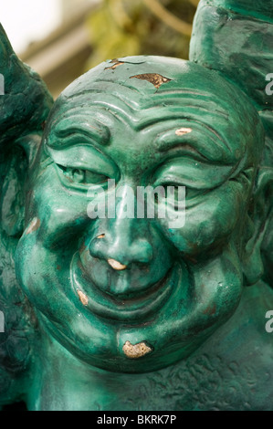 Primo piano di una statua verde di PU-tai, il Buddha che ride, un monaco Zen che simboleggia la felicità, la buona fortuna e la abbondanza. Foto Stock