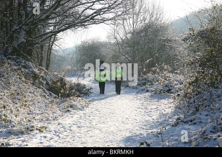Due comunità ufficiali di polizia a piedi lungo una coperta di neve percorso in corrispondenza Bathpool, Kidsgrove, Stoke-on-Trent, STAFFS Foto Stock