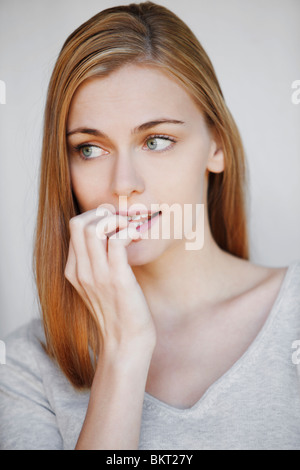 Ragazza che mangia le unghie Foto Stock